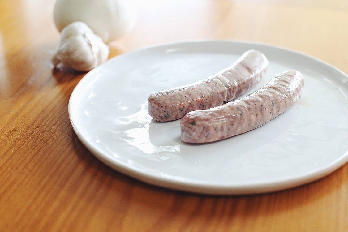 Raw sausage on plate for preparation
